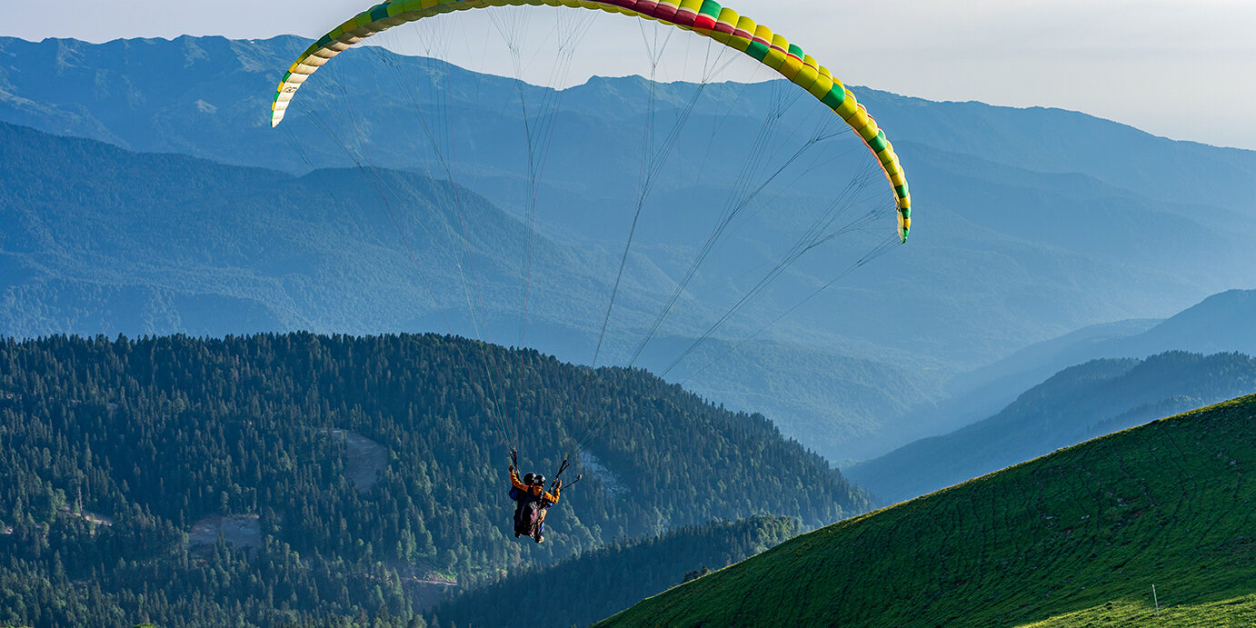 Yellow paraglider in blue clear sky over the Green Mountain Paraglider in blue clear sky over the Green Mountain