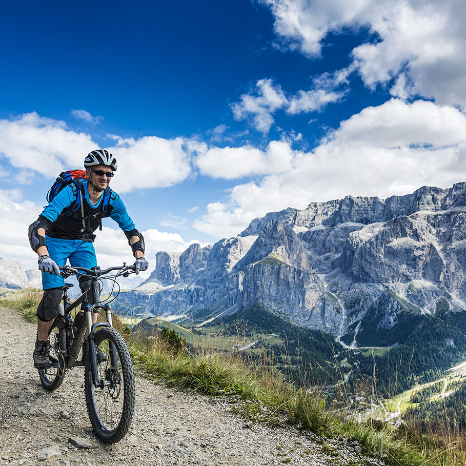 Two fully equiped male mountainbikers on their way on a gravel footpath in the Dolomites. In August 2009, the Dolomites were declared a UNESCO World Heritage Site.