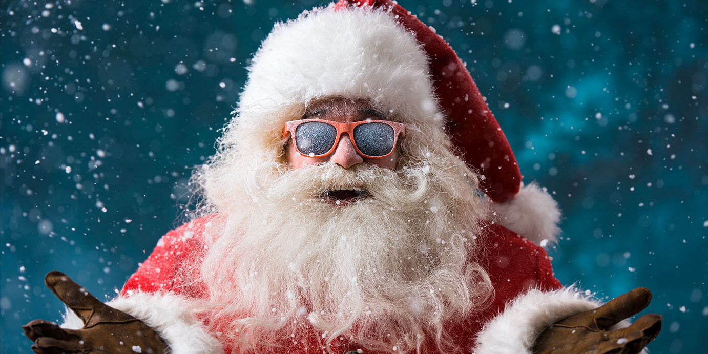 Santa,Claus,Wearing,Sunglasses,Dancing,Outdoors,At,North,Pole,In Santa Claus wearing sunglasses dancing outdoors at North Pole in snowfall. He is celebrating Christmas after hard work
