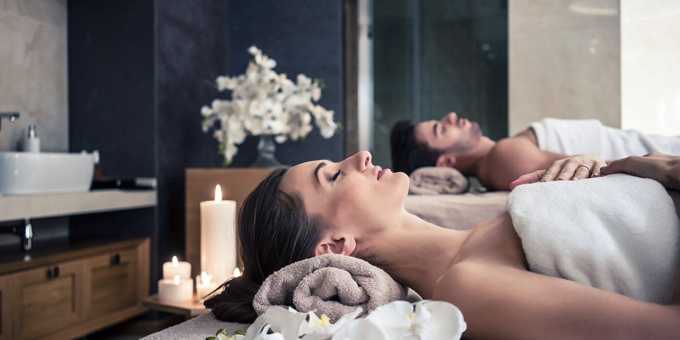 Man and woman lying down on massage beds at Asian wellness cente