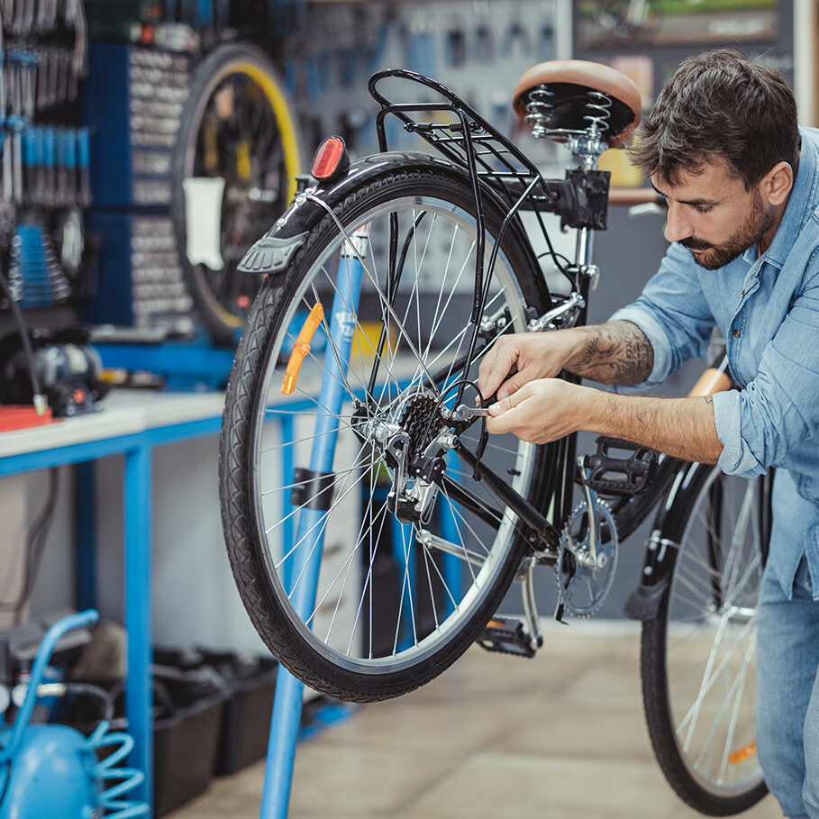 Shot of a young man working in a bicycle repair shop