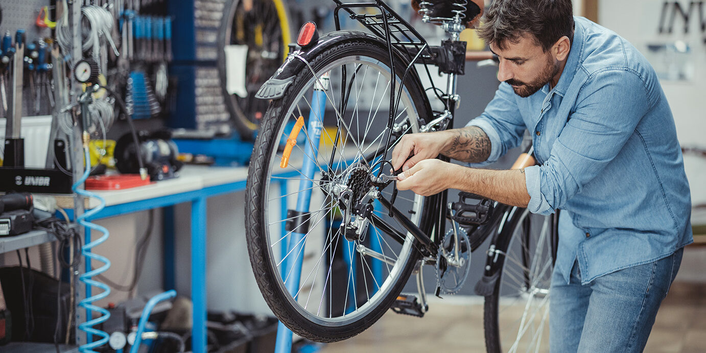 Shot of a young man working in a bicycle repair shop