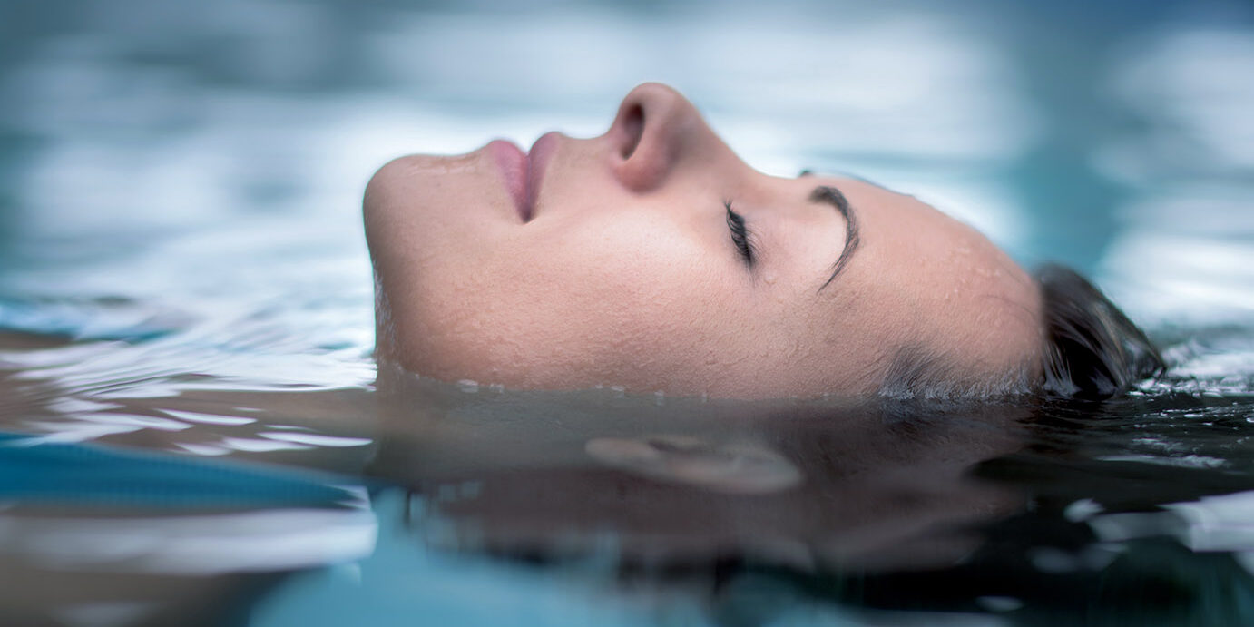 Woman at the spa relaxing at the swimming pool Woman at the spa relaxing at the swimming pool floating with eyes closed