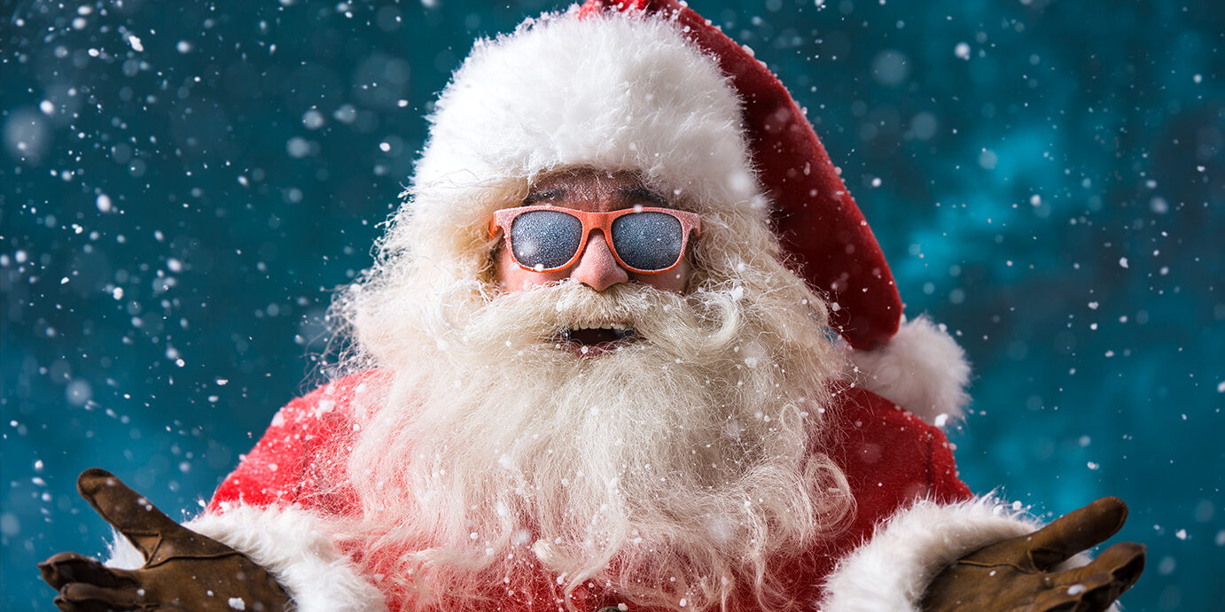 Santa,Claus,Wearing,Sunglasses,Dancing,Outdoors,At,North,Pole,In Santa Claus wearing sunglasses dancing outdoors at North Pole in snowfall. He is celebrating Christmas after hard work
