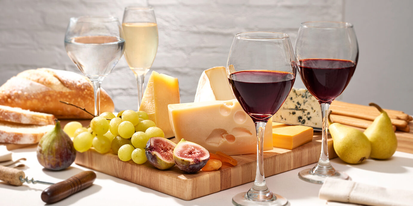 Table with cheese and fruit board Table with cheese and fruit board, accompanied by different wines
