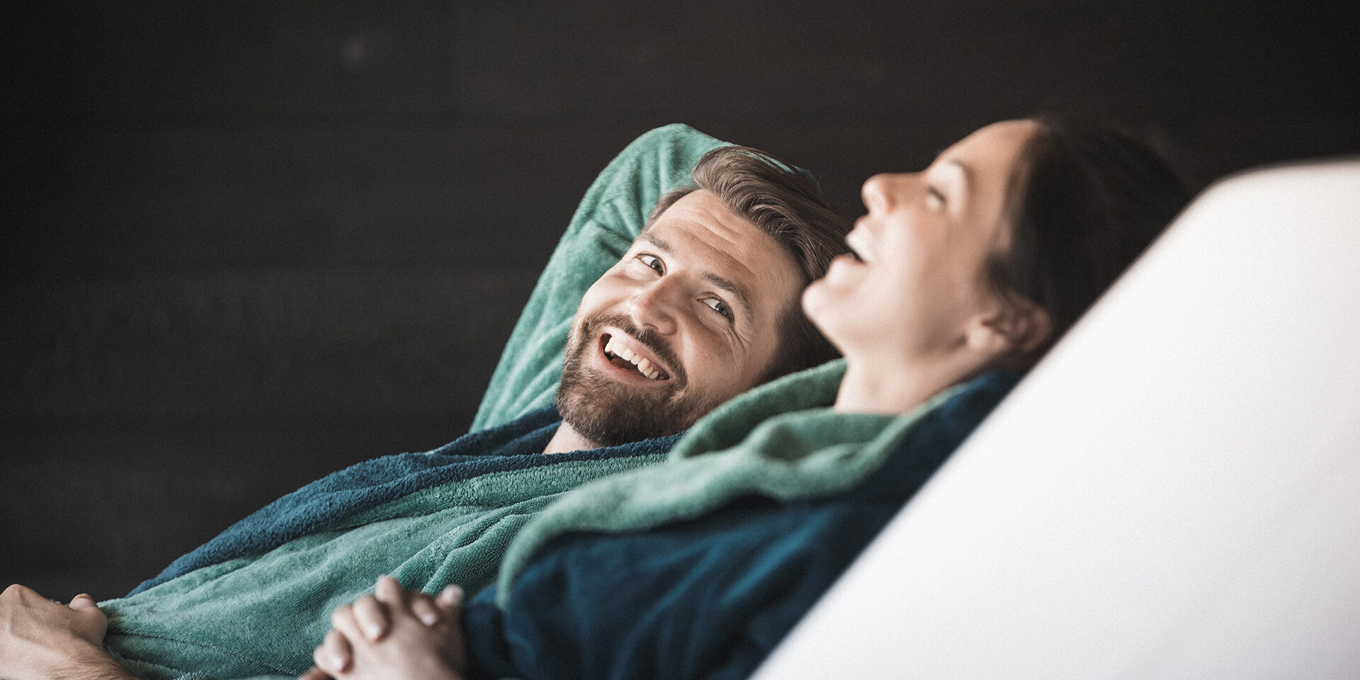 A couple sitting on lounge chairs in a wellness hotel. They are relaxing.