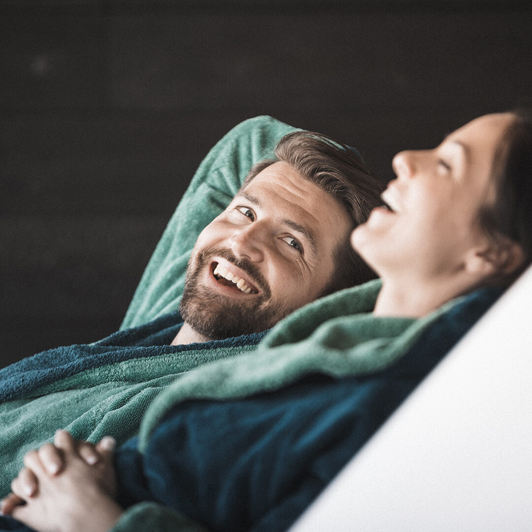 A couple sitting on lounge chairs in a wellness hotel. They are relaxing.