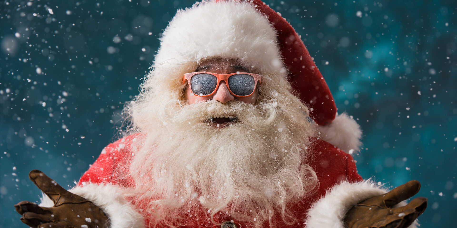 Santa Claus wearing sunglasses dancing outdoors at North Pole in snowfall. He is celebrating Christmas after hard work