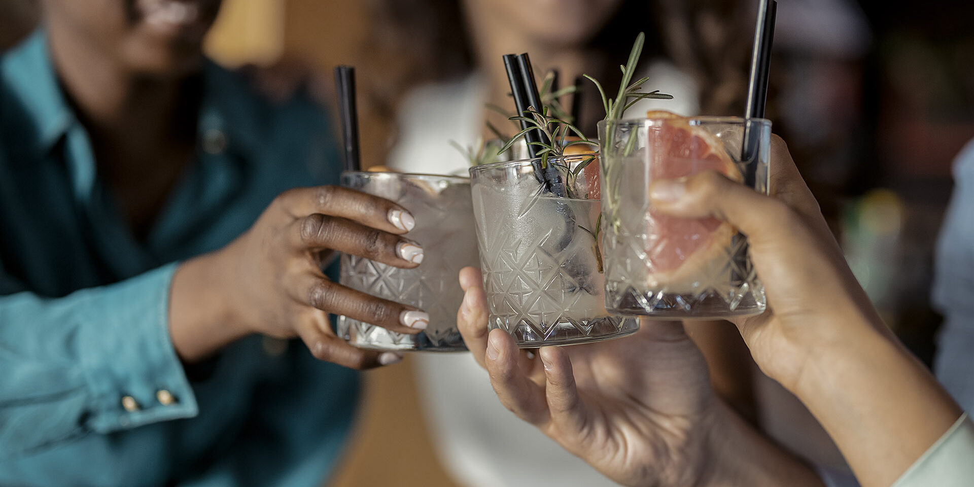 Here's to a successful business in the future People with alcohol drinks clinking glasses in a restaurant having fun together, laughing, drinking cocktails. Party, celebration, nightlife and people concept - smiling friends clinking glasses