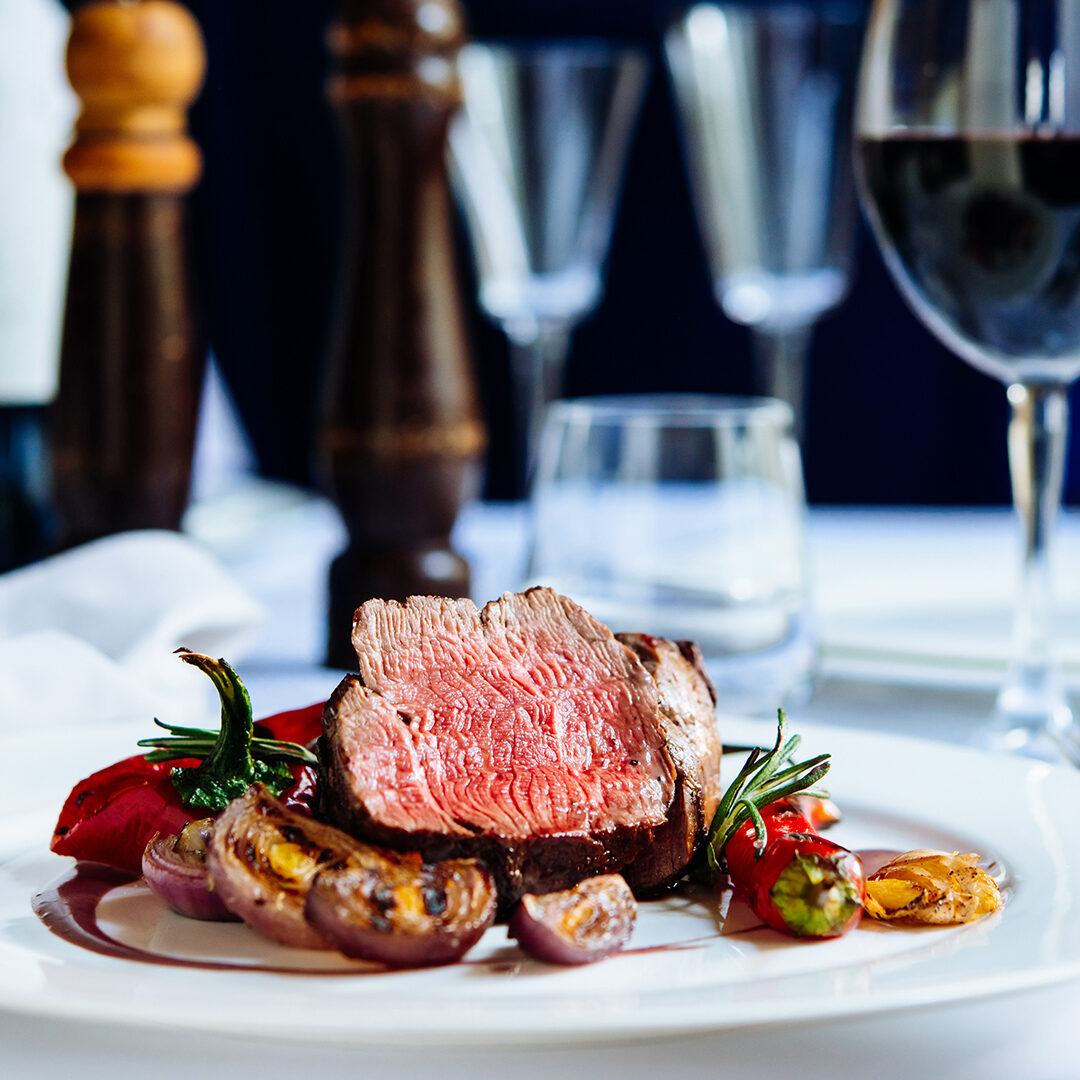 Beef steak with grilled vegetables served on white plate