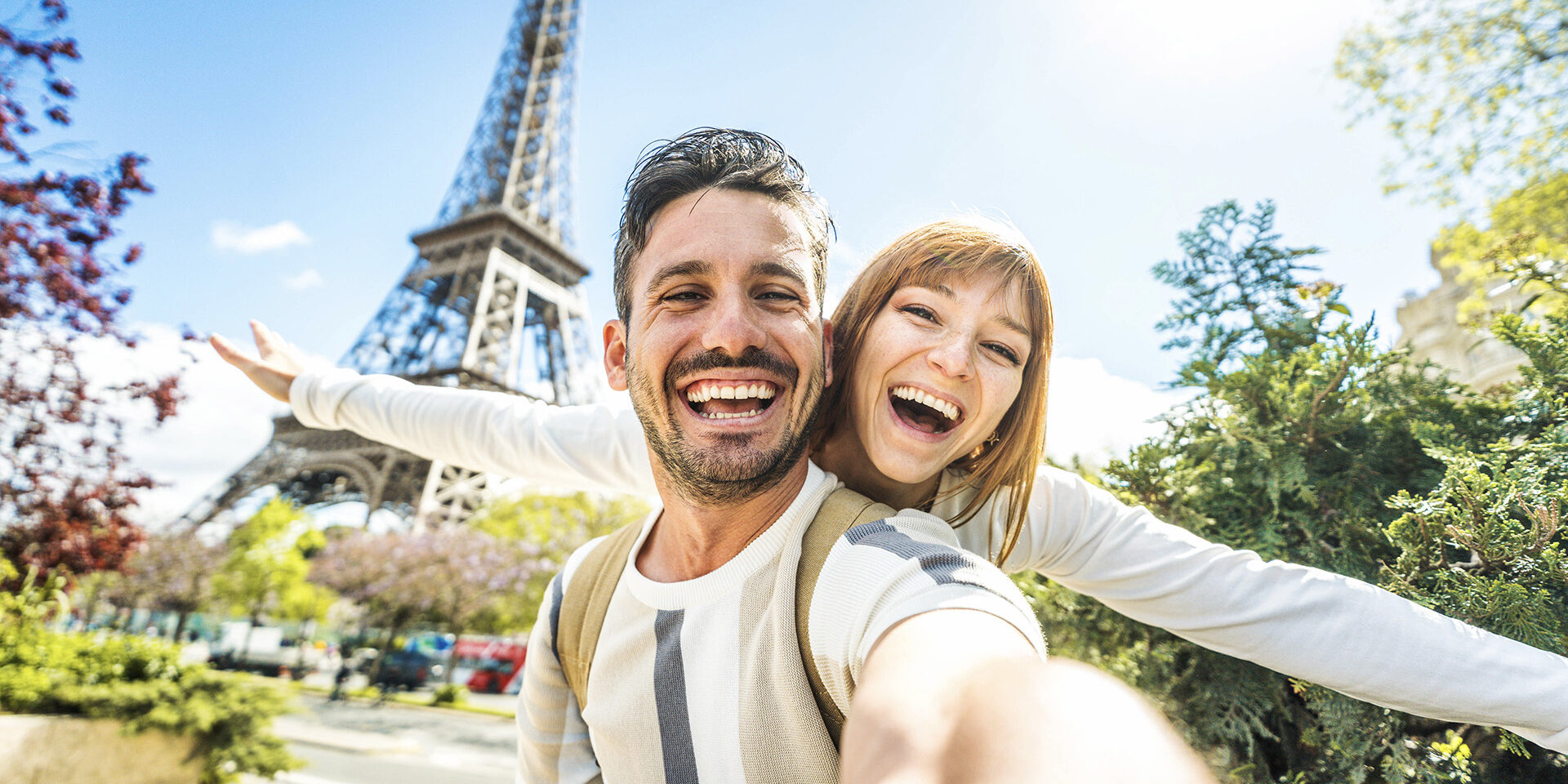 Happy couple of tourists taking selfie picture in front of Eiffel Tower in Paris, France - Travel and summer vacation life style concept