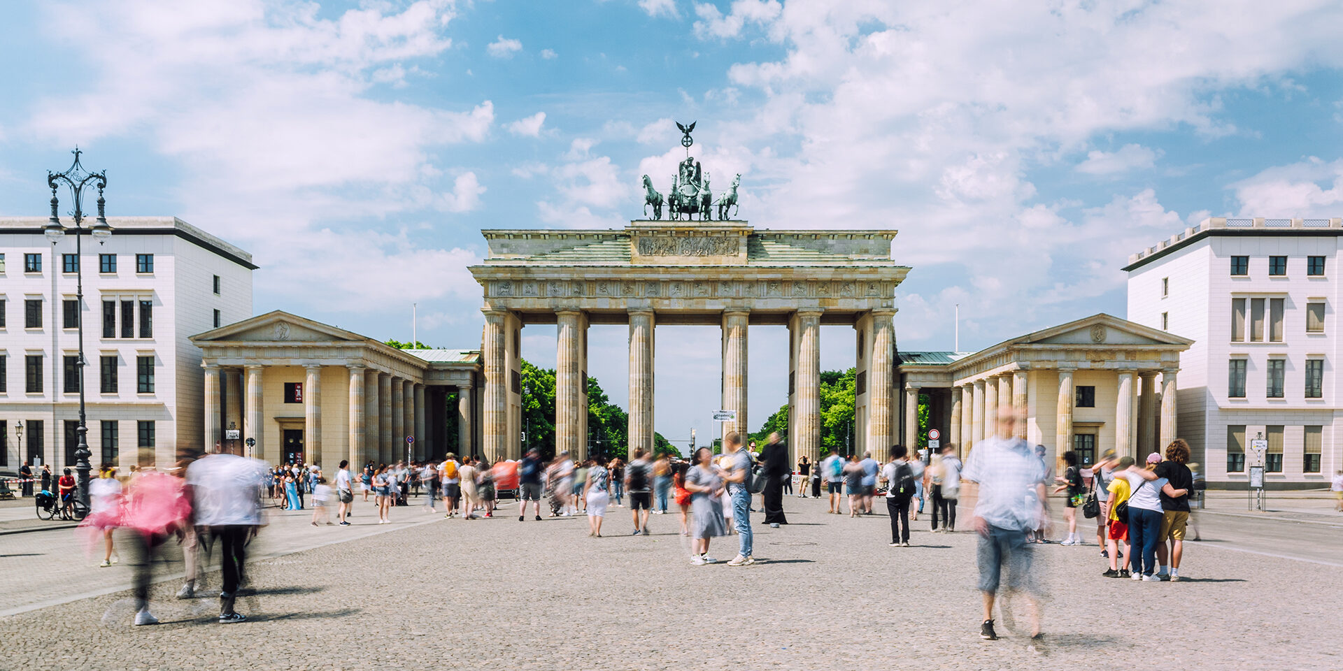 Dynamic crowd, Brandenburg Gate, Berlin, daytime, bustling city, blurred motion, lively atmosphere.
Berlin, Germany