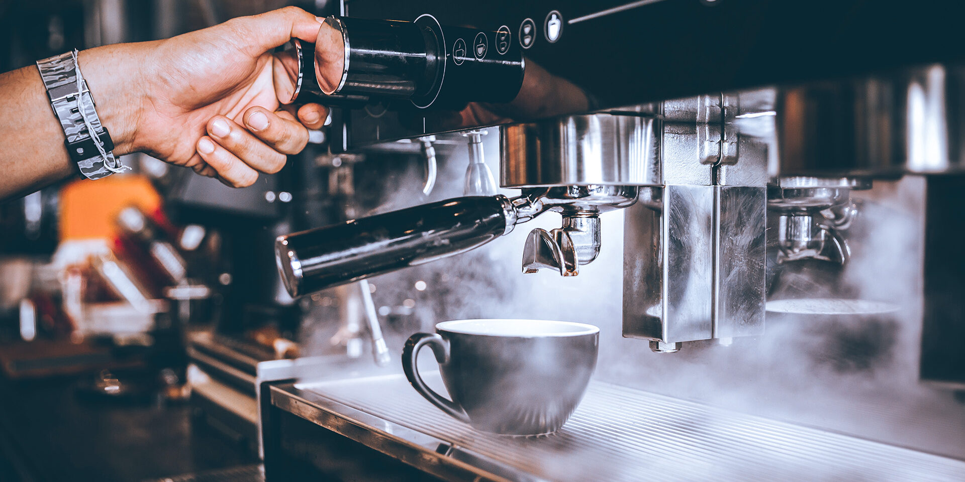 Barista making fresh coffee with machine in coffee shop or cafe.