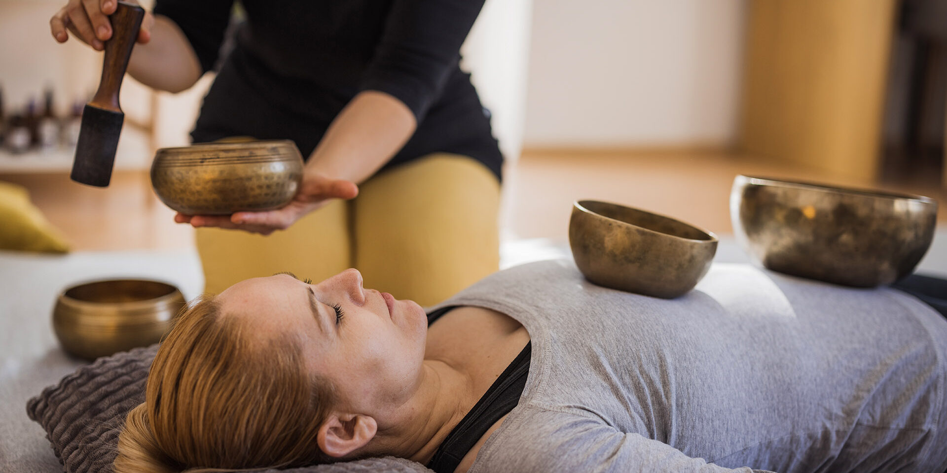 Frequency therapy with Tibetan singing bowls Female healer using Tibetan singing bowls during therapy session