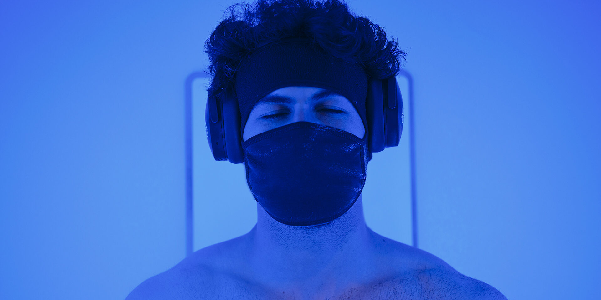 A young adult man in a cryotherapy chamber in a biohacking lab.