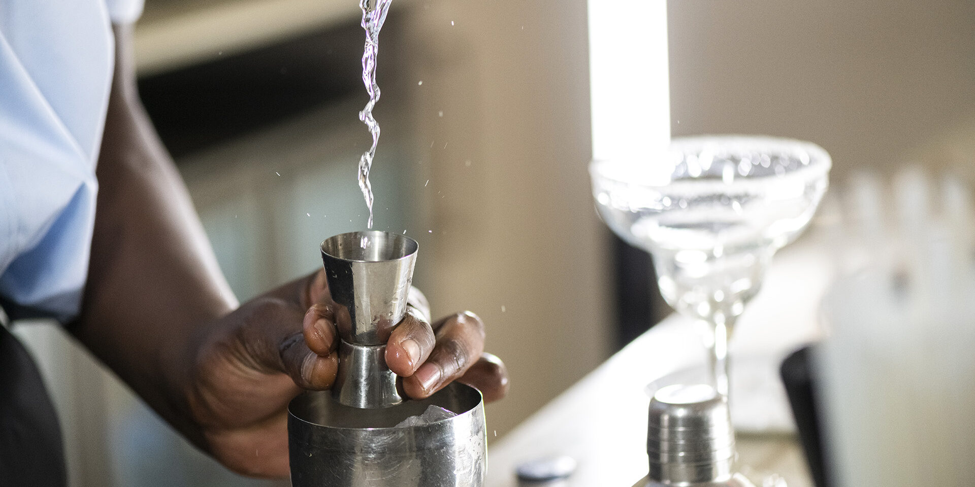 Barman pouring alcohol into cocktail shaker Barman pouring alcohol into cocktail shaker