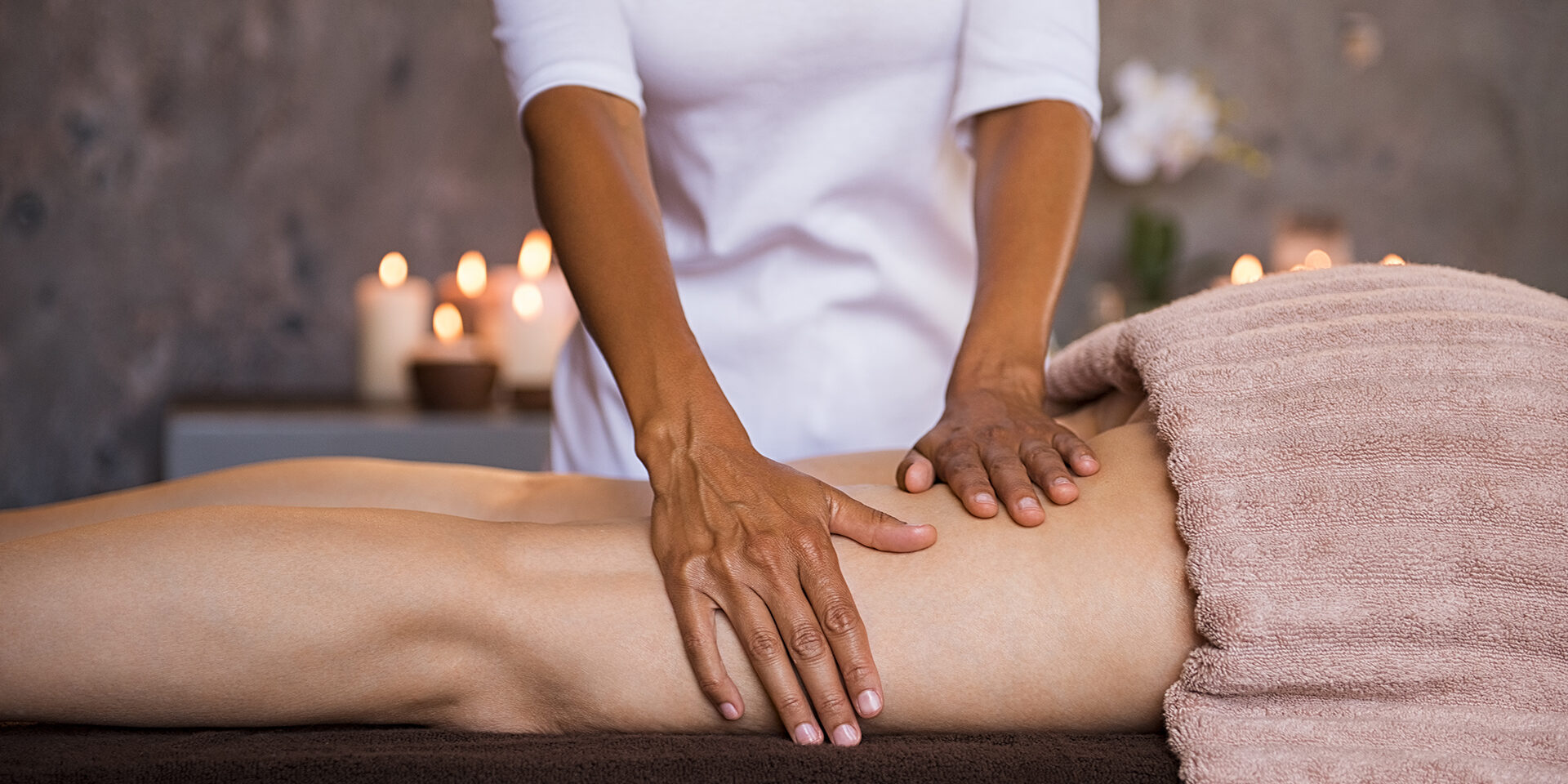 Anti cellulite leg treatment Therapeutic massage for senior woman by beautician at spa salon. Closeup of professional masseuse hands massaging woman legs at wellness center. Anti cellulite treatment and leg drainage on mature woman.