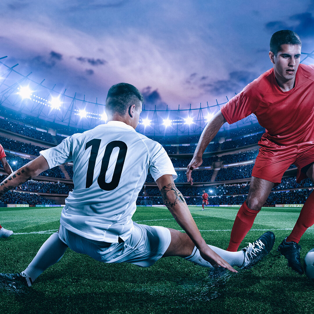 Soccer player in action on a professional arena full of spectators