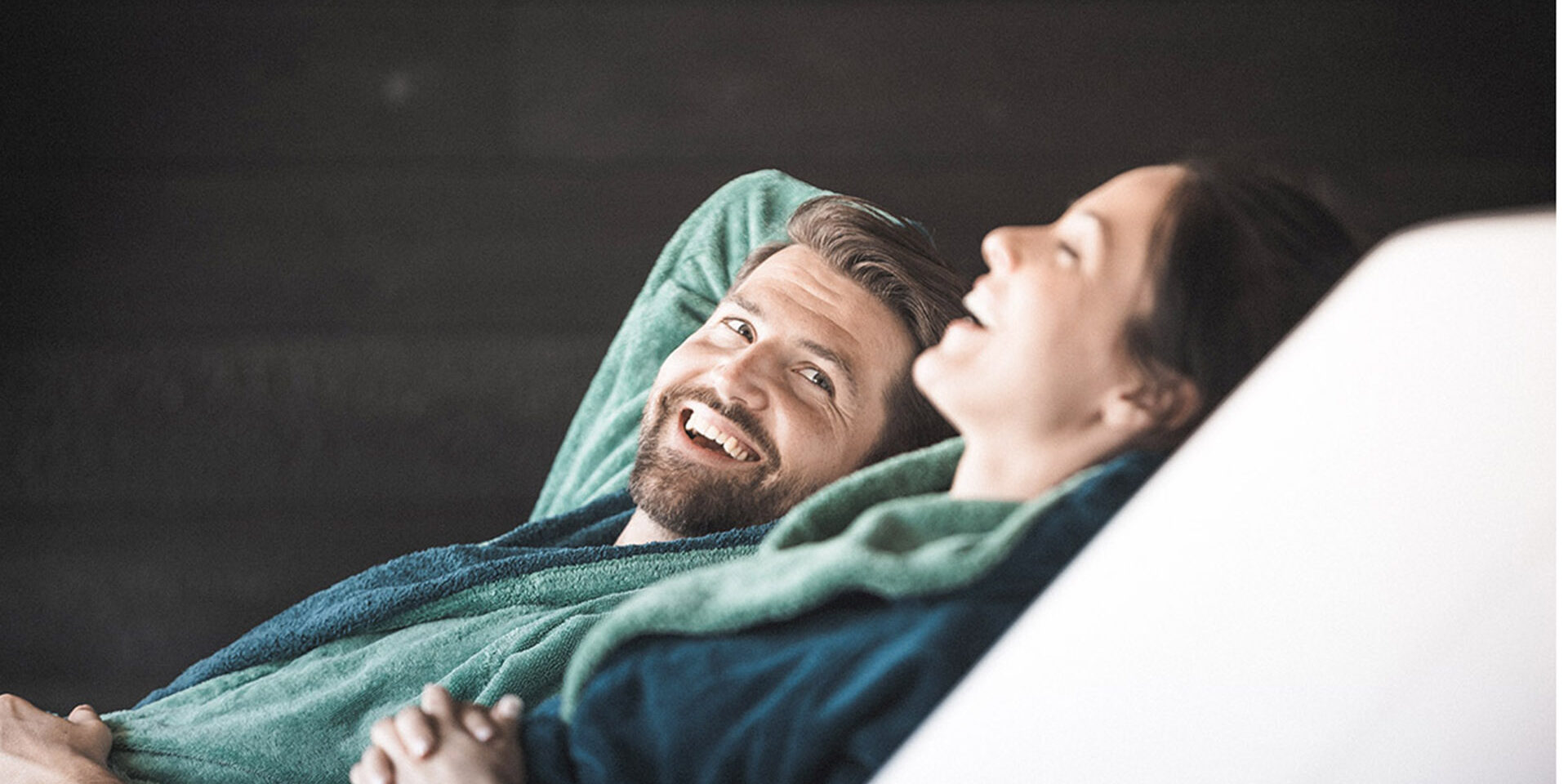 A couple sitting on lounge chairs in a wellness hotel. They are relaxing.