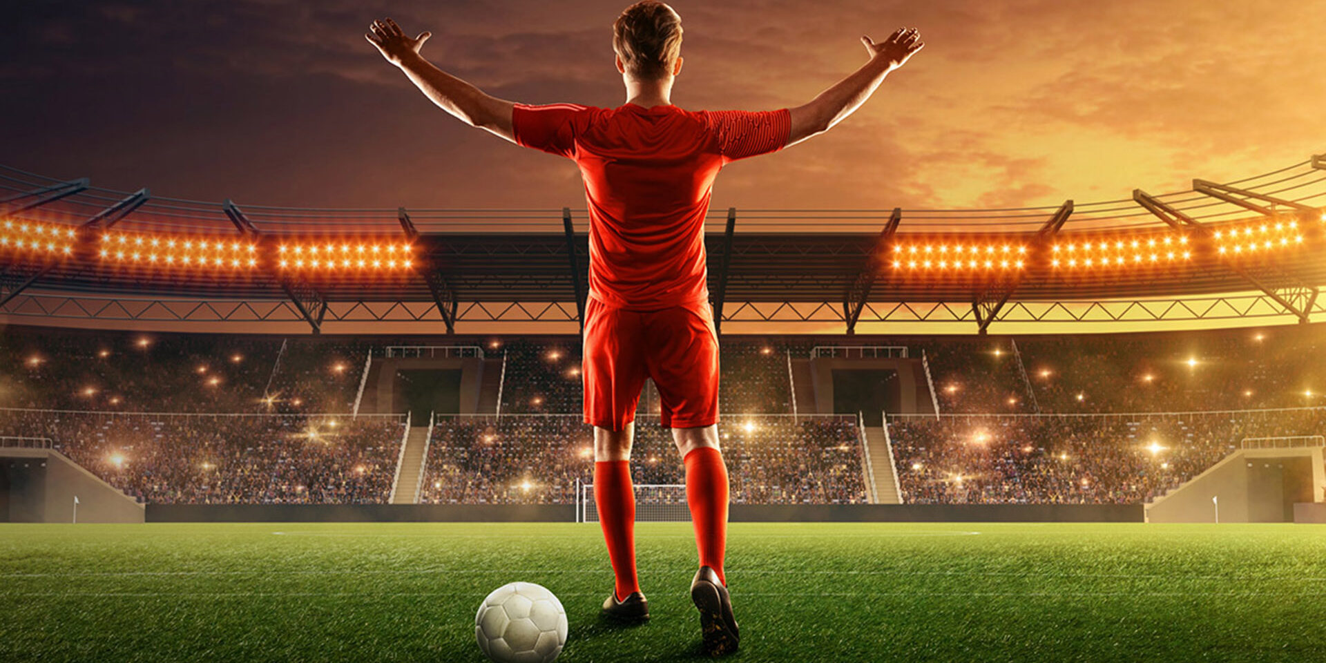 Professional soccer player with a ball on a floodlit stadium. Night soccer stadium with fans cheering and dramatic sky. Sports event. Celebrating the victory