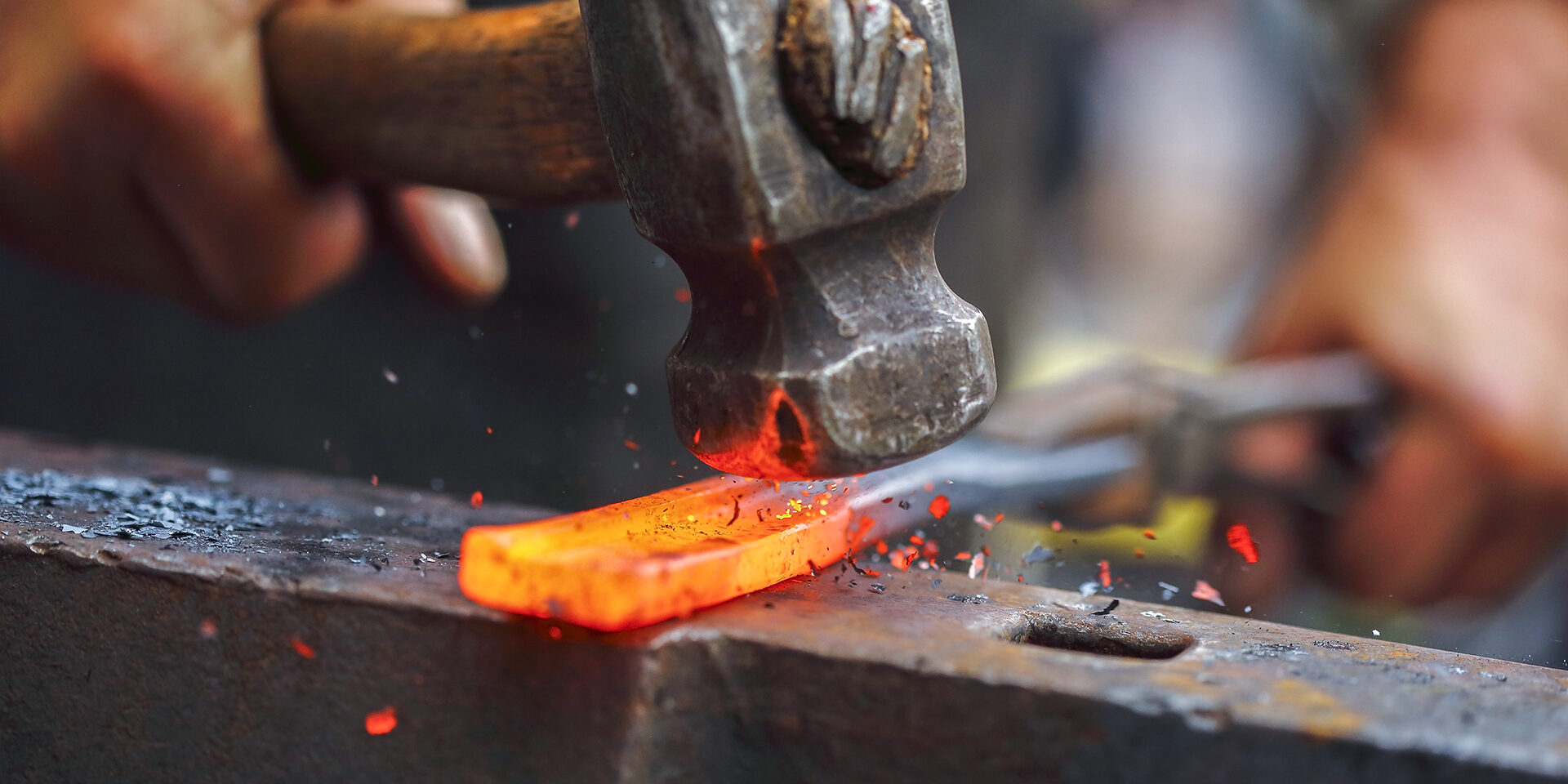 Forging hot iron Detail shot of hammer forging hot iron at anvil