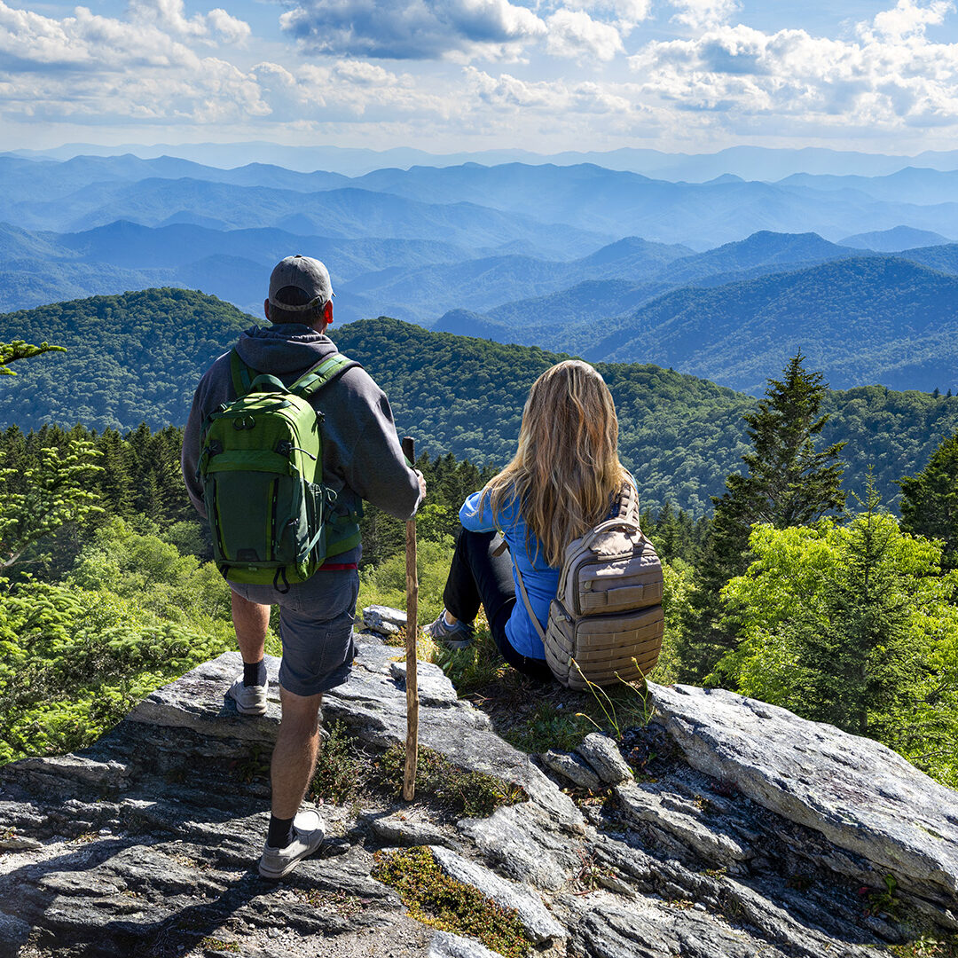 Couple on top of the mountain enjoying beautiful view. Blue Ridge Mountains, near Asheville, North Carolina.USA.