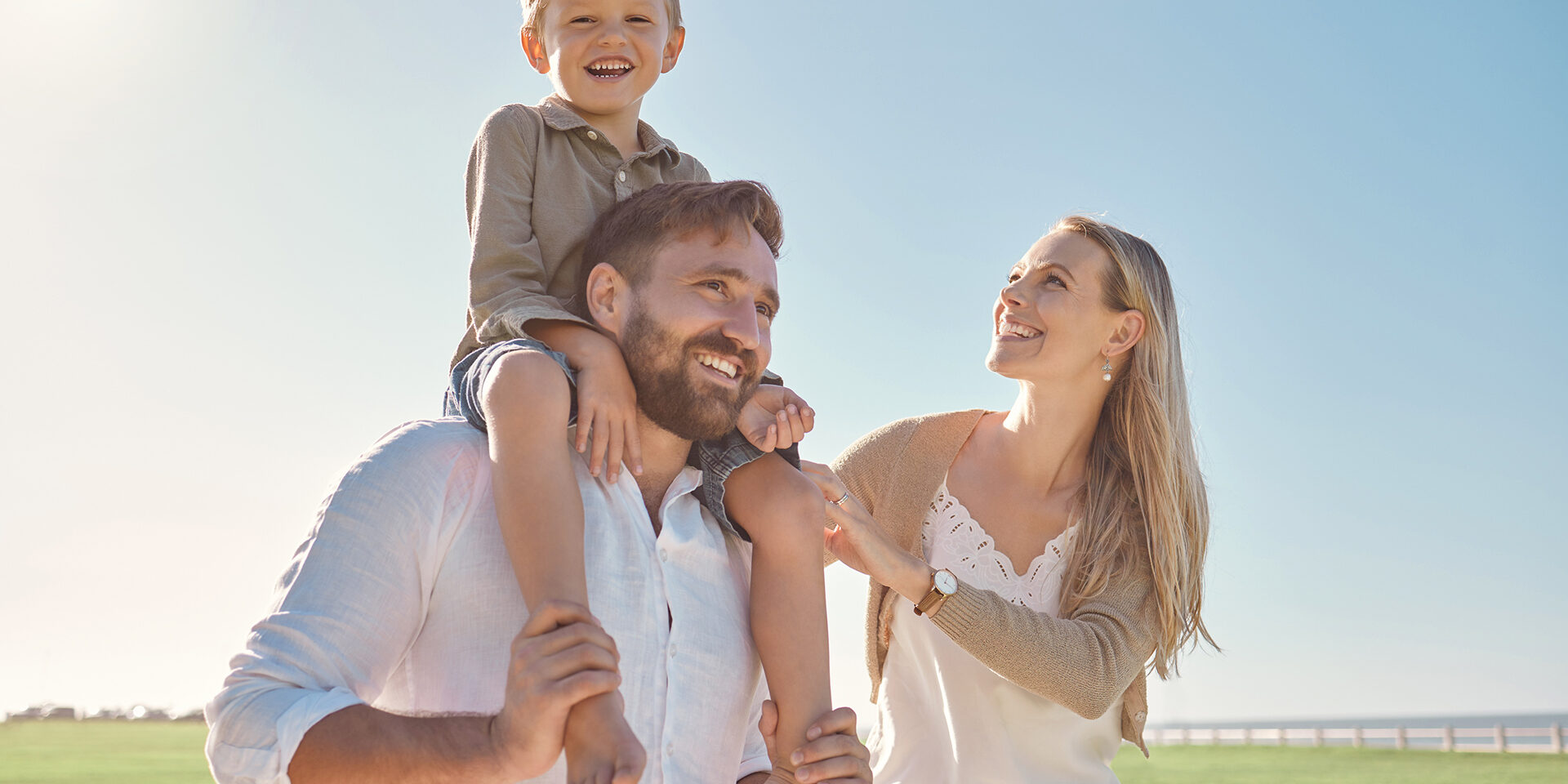 Walk, smile and child with parents in a park for freedom, peace and happiness during summer. Portrait of a happy, free and relax kid with his mother and father walking in a nature field with love