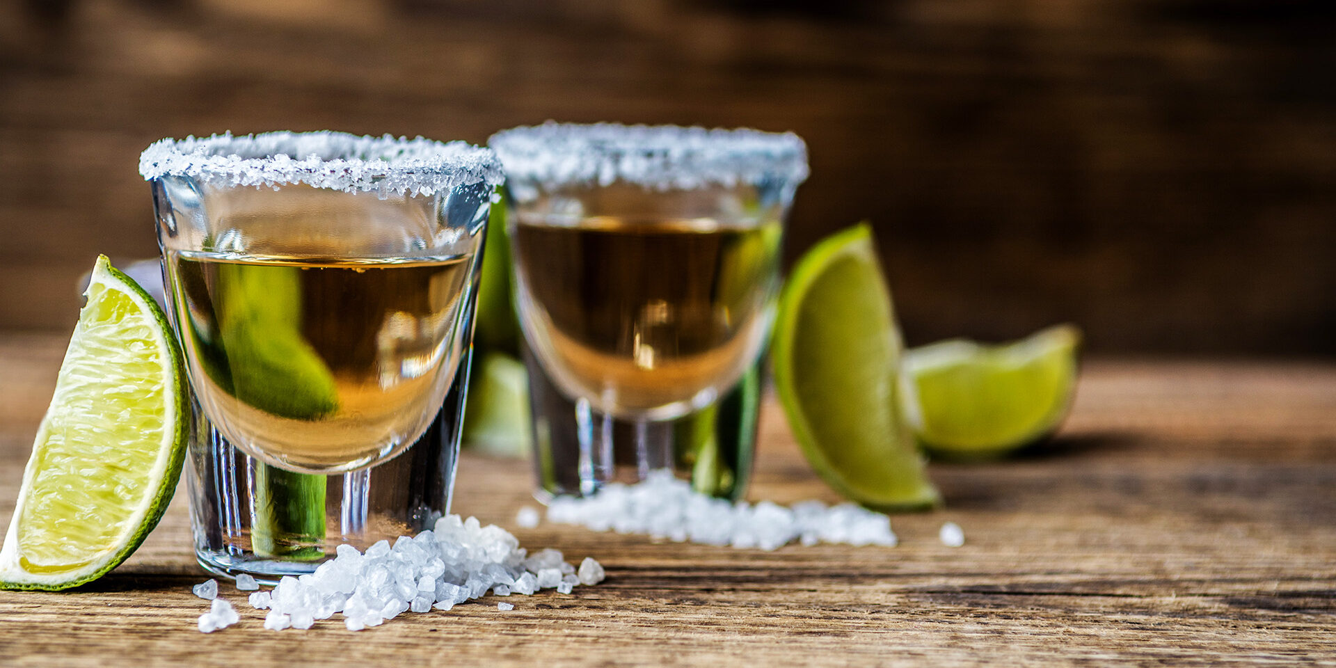 Tequila with lime Mexican traditional alcohol drink Tequila with lime and salt and ice cube on wood table