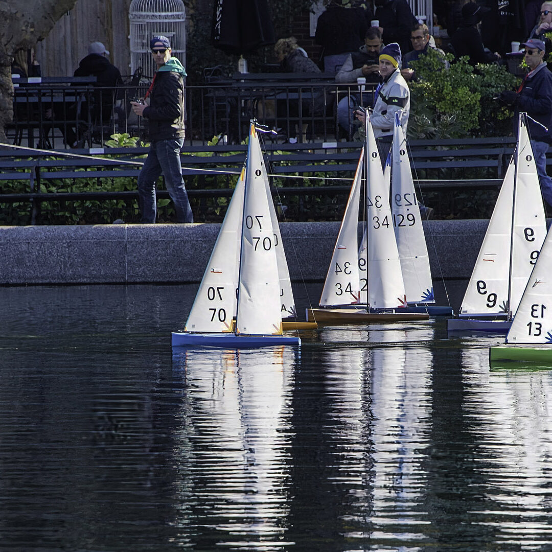 Conservatory Water, also known as the Model Boat Basin, is a picturesque and tranquil spot located in Central Park, New York City. The large, classically-designed pond was originally intended to be part of a formal conservatory, hence its name, but the conservatory was never built. Instead, the area became known for its use as a model boat pond, where enthusiasts could sail their miniature, remote-controlled boats.