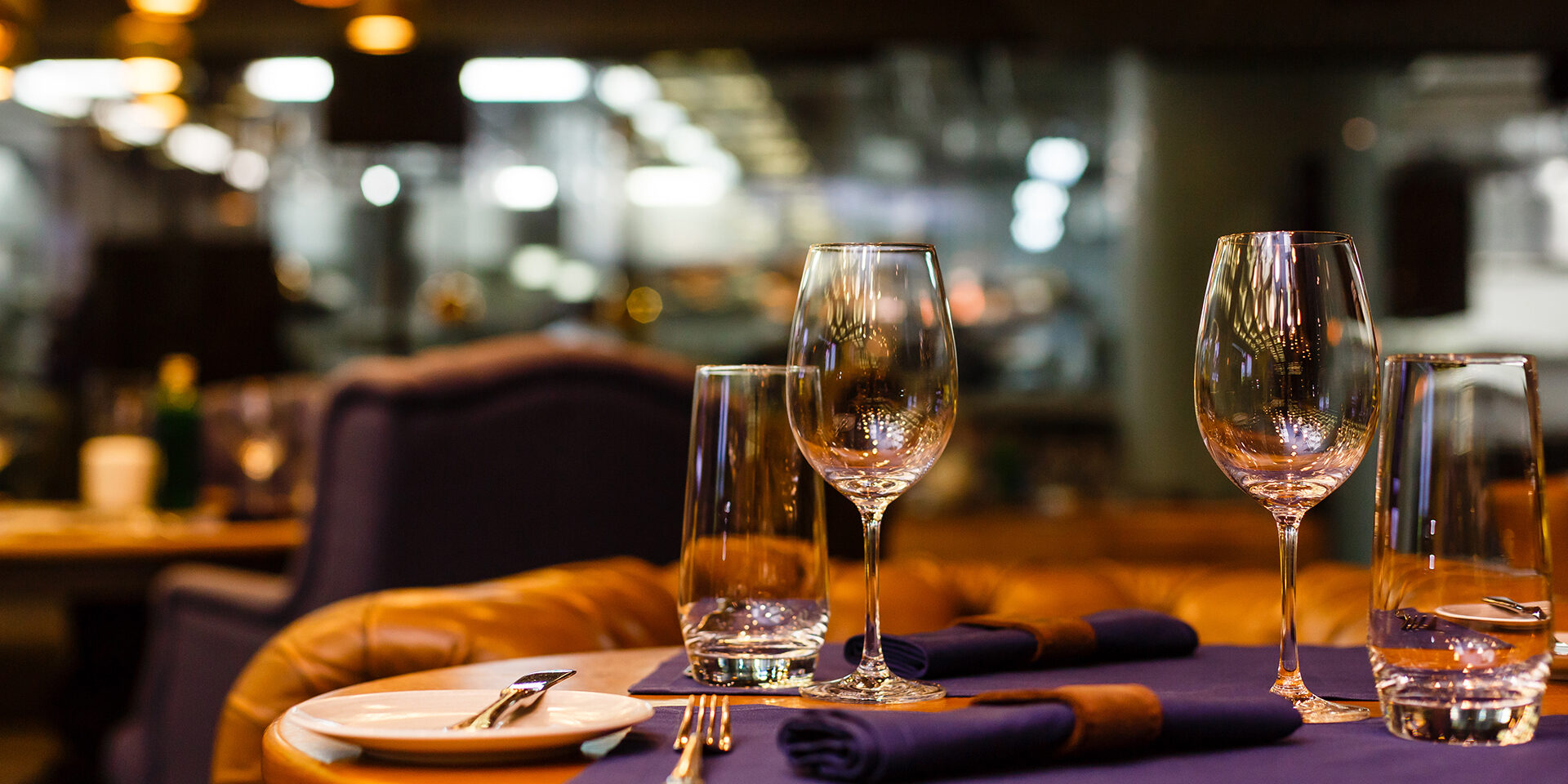 Two empty wine glasses sitting in a restaurant on a warm sunny afternoon.