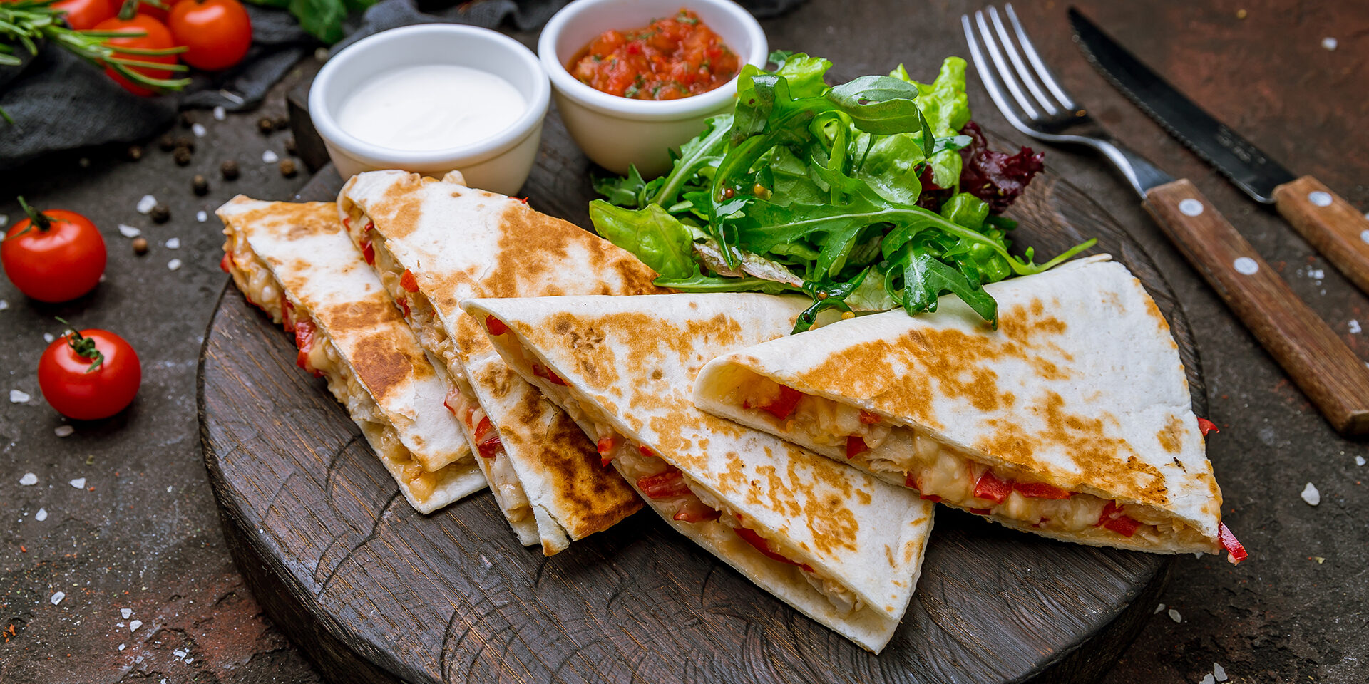 Quesadilla with chicken and sauces Quesadilla with chicken and sauces on dark board , on dark rustic concrete background