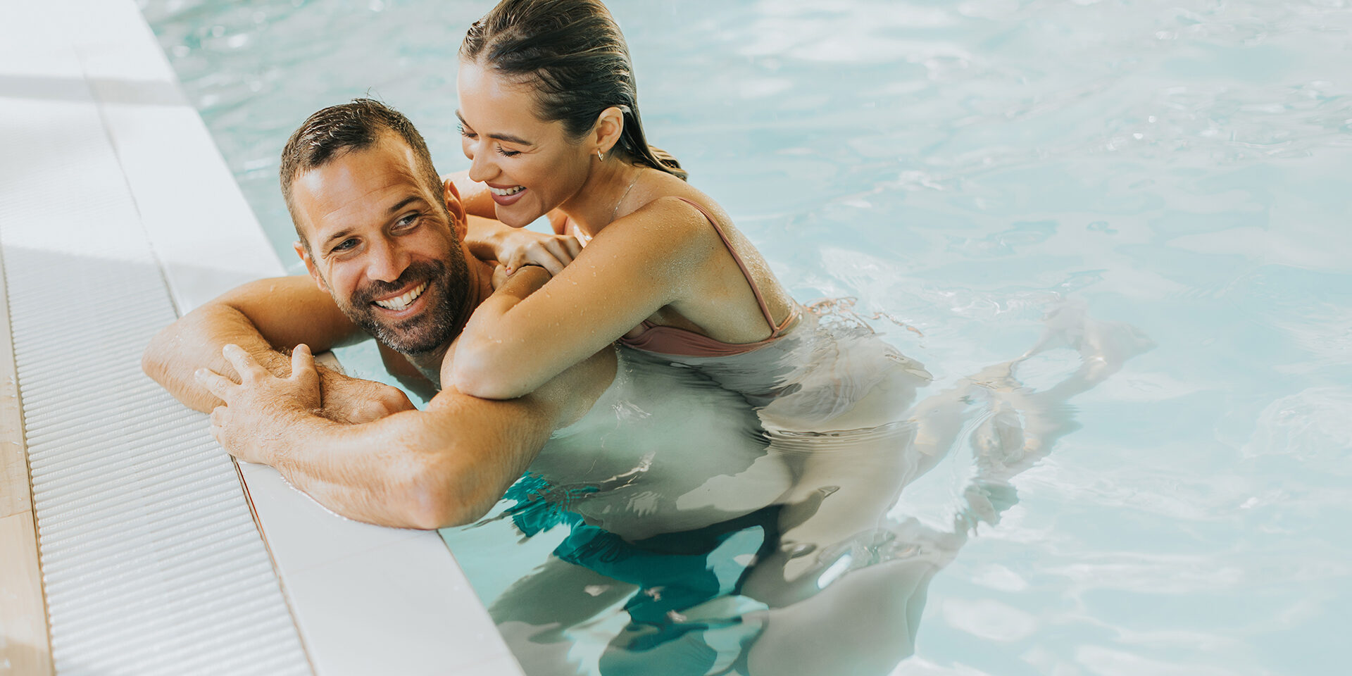 Handsome young couple relaxing in the indoor swimming pool