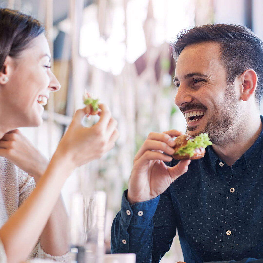 Happy loving couple enjoying breakfast in a cafe. Love, dating, food, lifestyle