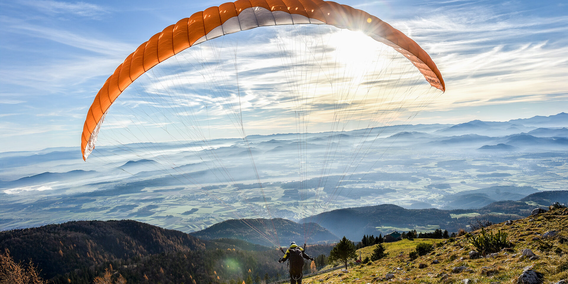 Paraglider is flying in the valley. Paragliding from the mountain with perfect view