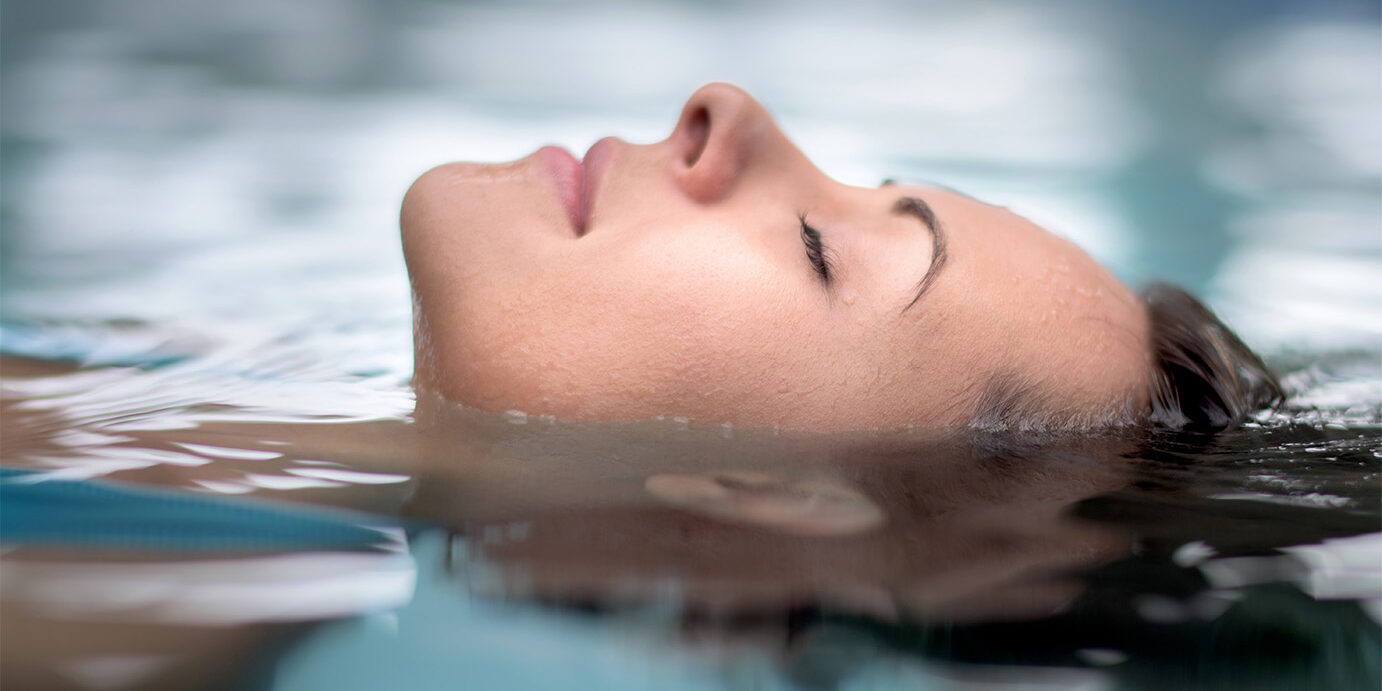Woman at the spa relaxing at the swimming pool Woman at the spa relaxing at the swimming pool floating with eyes closed